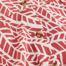 Load image into Gallery viewer, Close-up of a red and white patterned shirt with buttons.
