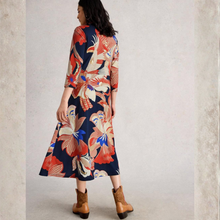 Load image into Gallery viewer, Woman wearing a colorful floral dress with brown boots on a plain background
