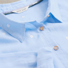 Load image into Gallery viewer, Close-up of a light blue polo shirt with a collar and buttons, featuring the brand 'White Stuff'.
