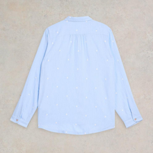 Load image into Gallery viewer, Light blue shirt with small white polka dots on a beige background
