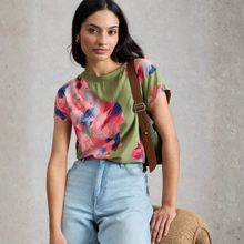 Load image into Gallery viewer, Woman wearing a floral top and jeans with a brown bag against a gray background
