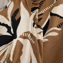 Load image into Gallery viewer, Close-up of a fabric with a brown, black, and white abstract pattern.
