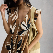 Load image into Gallery viewer, Woman wearing a patterned dress with a plain background
