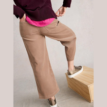 Load image into Gallery viewer, Person wearing brown pants and a pink shirt, standing on a wooden block against a plain background
