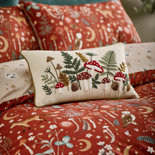 Load image into Gallery viewer, Decorative pillow with embroidered design on a matching bedspread with festive patterns.
