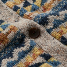 Load image into Gallery viewer, Close-up of a textured knit cardigan with a geometric multicolor pattern in blue, yellow, orange, and cream, featuring a single brown button.
