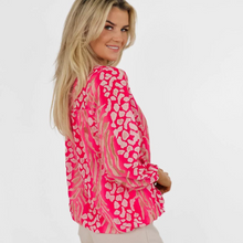 Load image into Gallery viewer, Female model wearing pink top looking over the shoulder smiling
