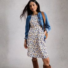 Load image into Gallery viewer, Woman wearing a floral dress with a denim jacket and brown boots against a gray background
